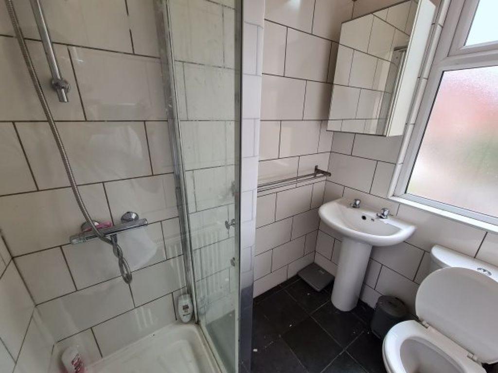 A clean and well-lit bathroom with a large show...