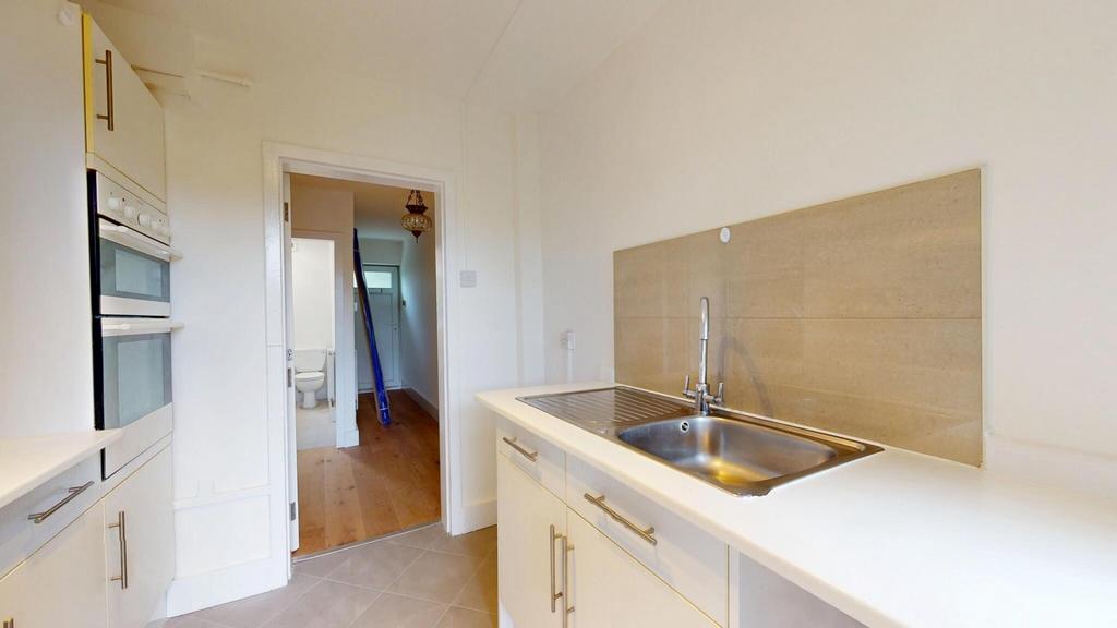 Bright and clean kitchen area with modern fixtu...