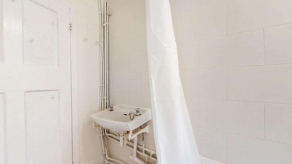 A clean, bright bathroom with a visible shower ...
