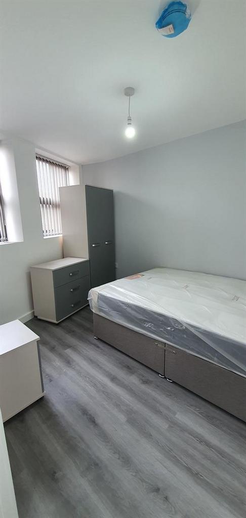 A bright and tidy single bedroom featuring a be...