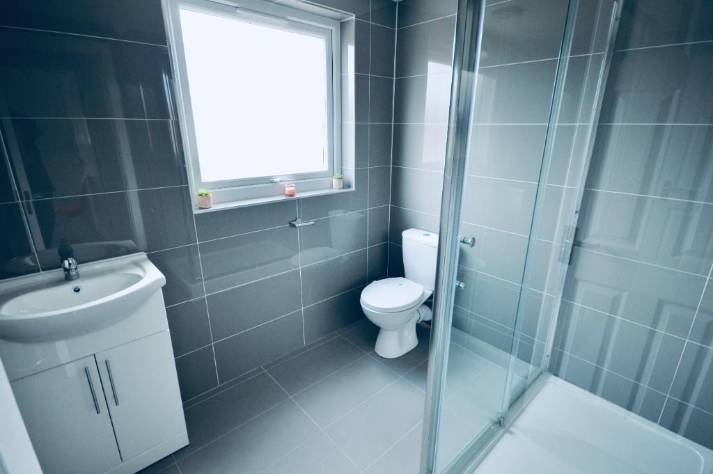 A modern, well-lit bathroom featuring a clean s...
