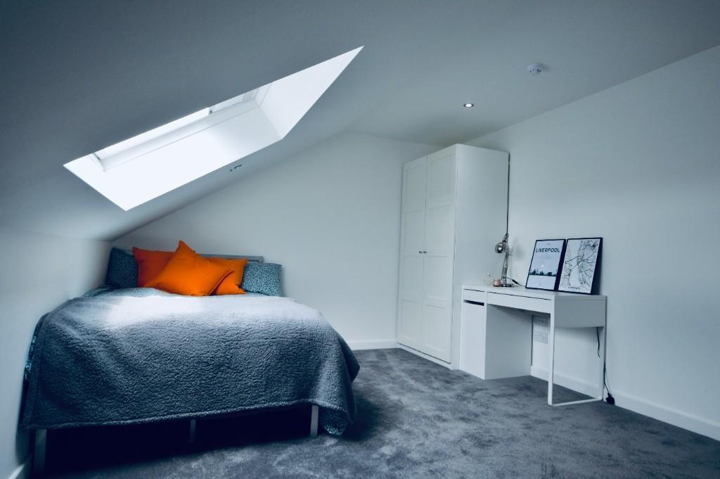 A bright and modern bedroom featuring a comfort...