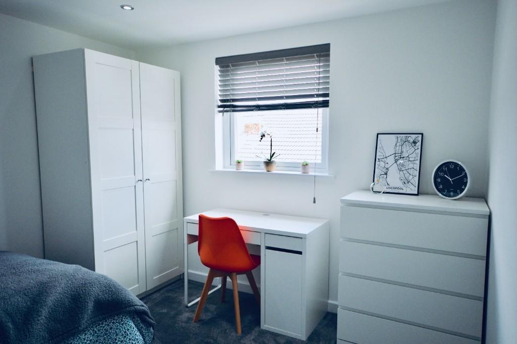 A modern and tidy bedroom featuring a white war...