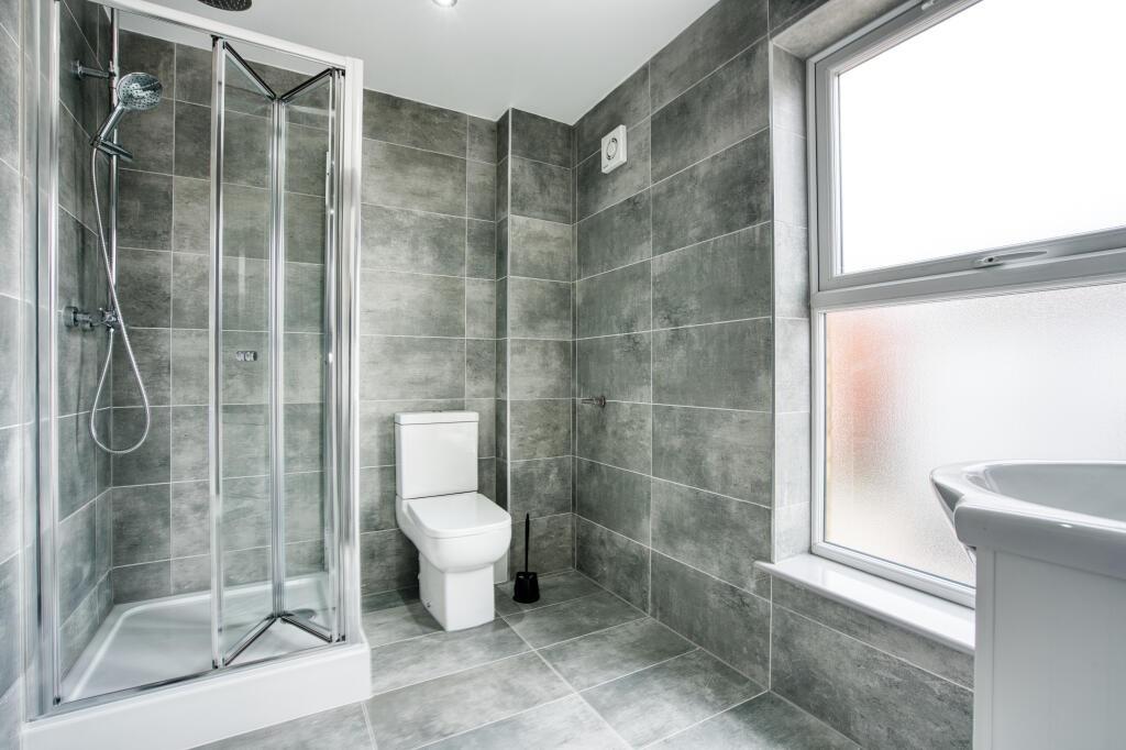 Modern and spacious bathroom with large window,...