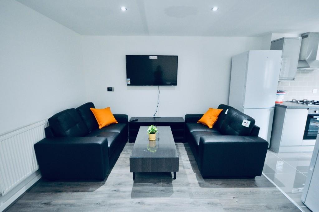 A modern, well-lit living room featuring two co...