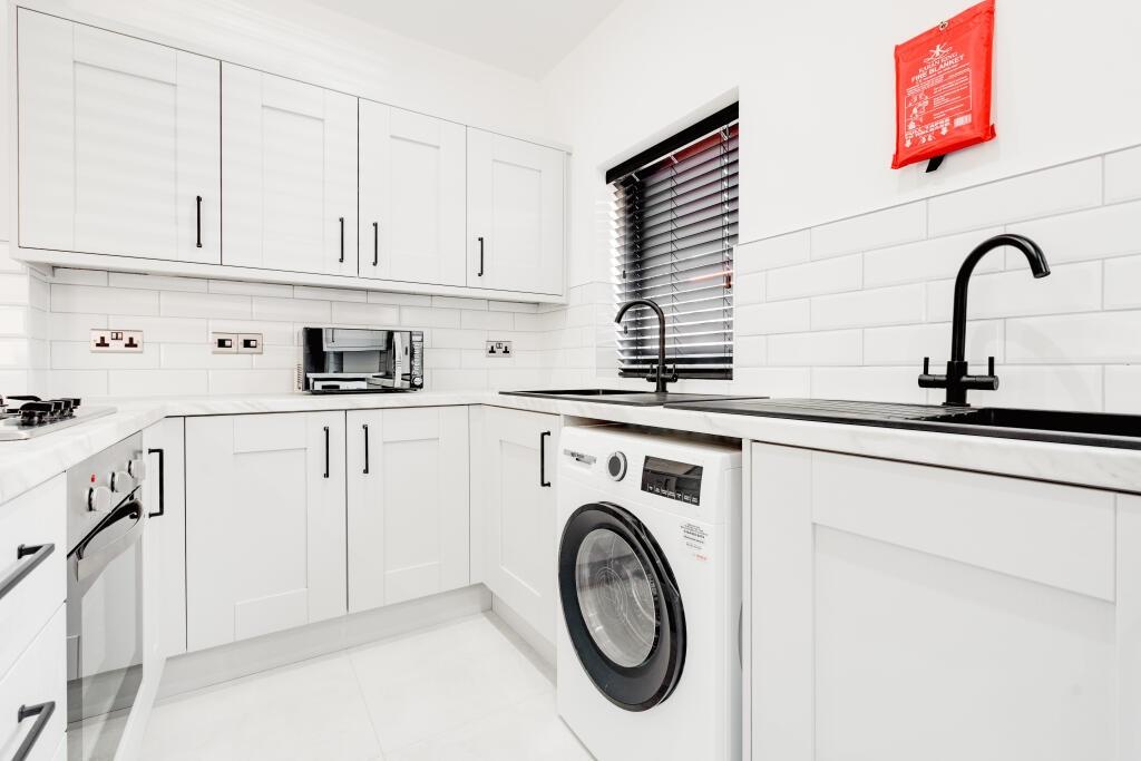 Modern, clean kitchen with ample white cabinetr...