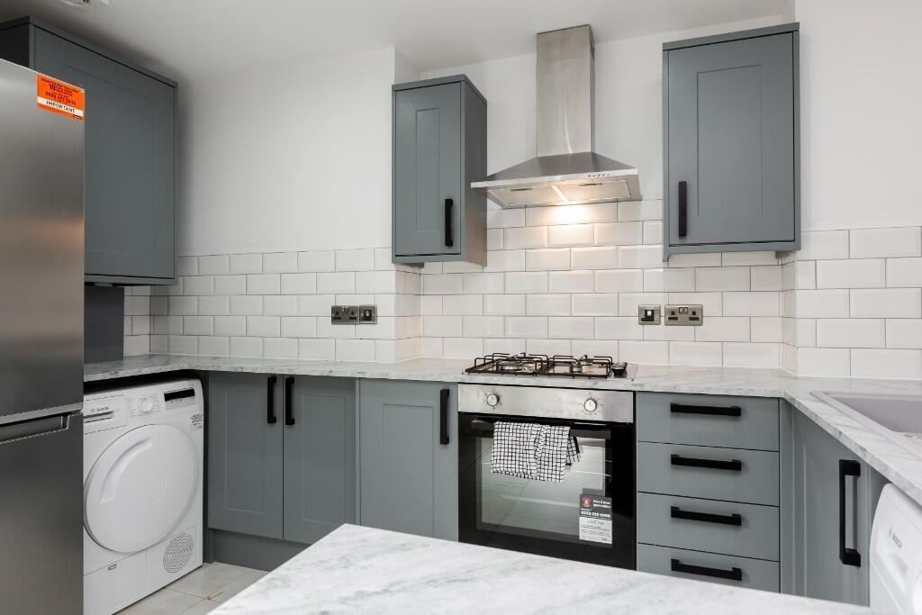 A modern, well-maintained kitchen with sleek gr...