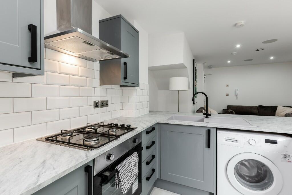 Modern kitchen with sleek grey cabinetry, a mar...