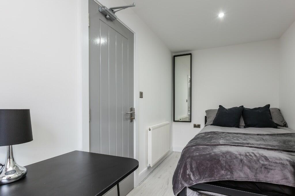 A modern, well-lit bedroom featuring a large do...