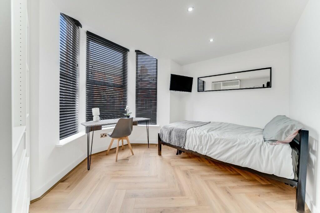 A bright, minimalist bedroom featuring large wi...