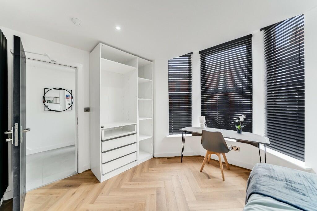 Bright and modern bedroom featuring large windo...