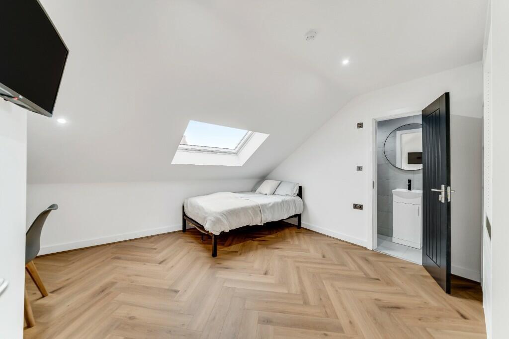 Bright and clean bedroom with a large window al...