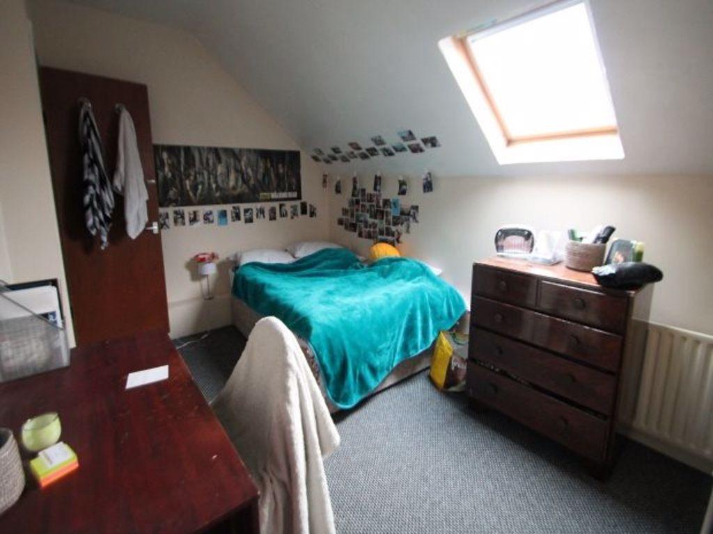A cozy bedroom featuring a single bed with a br...