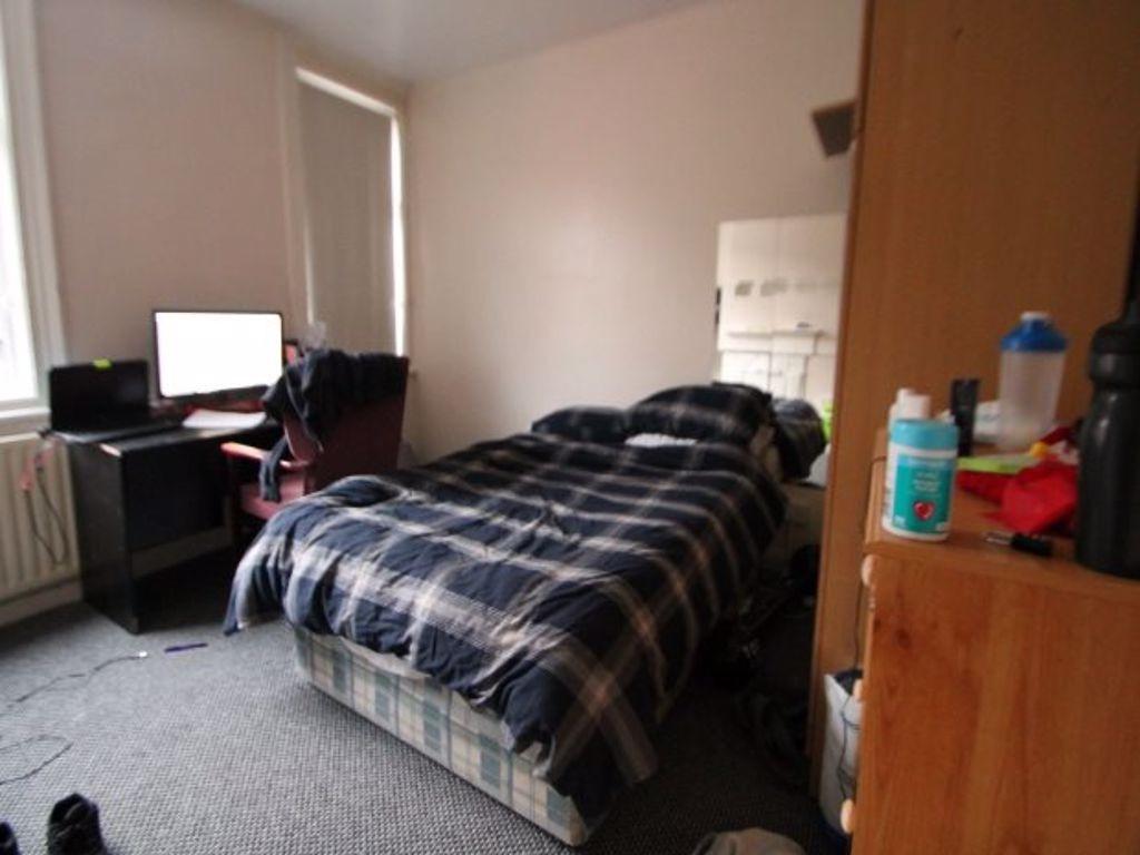 A cozy single bedroom featuring a neatly made b...