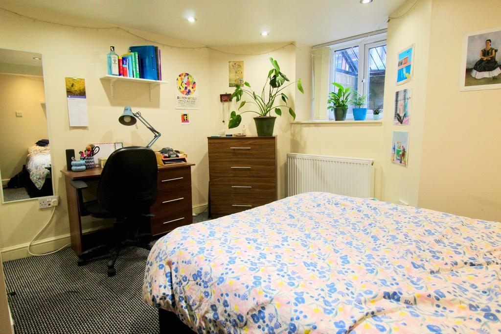 A well-maintained bedroom featuring a cozy bed ...