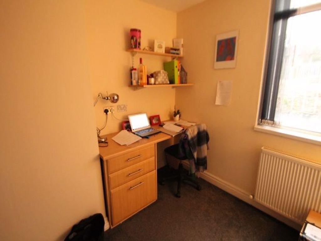 A small, well-lit bedroom with a window letting...