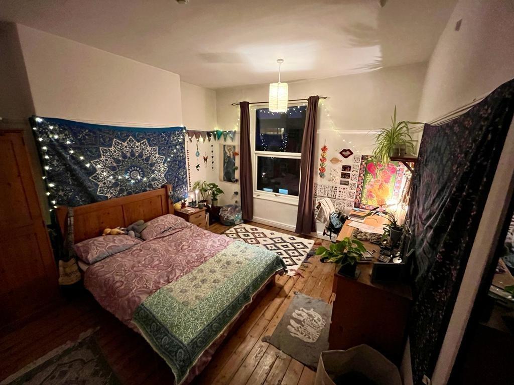 Warm, characterful double bedroom with wooden f...