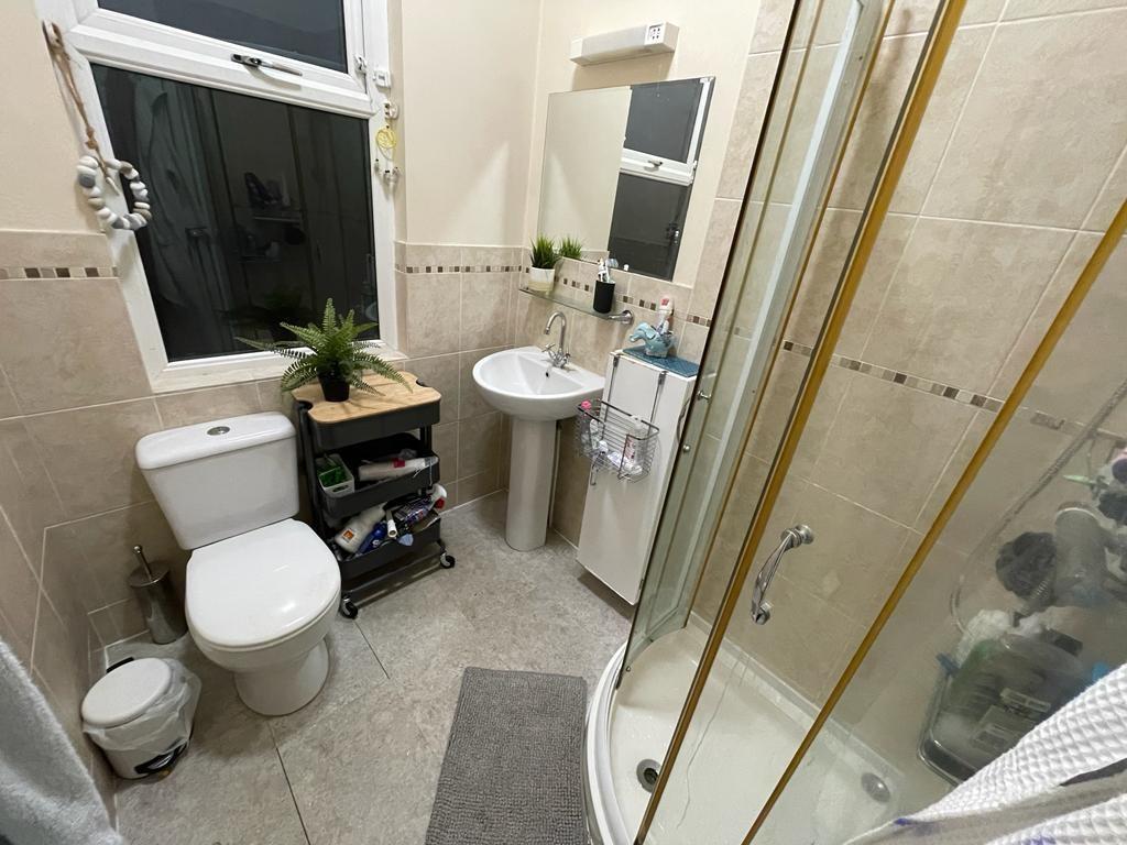 Well-maintained bathroom with a curved glass sh...
