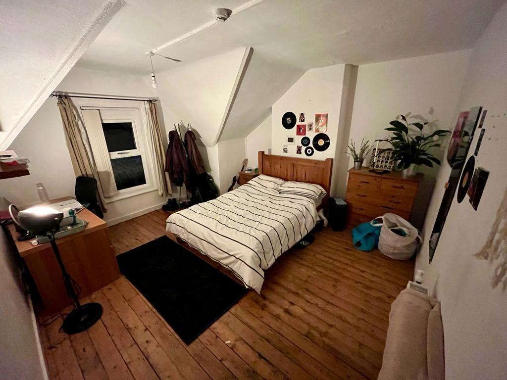 Bright, neatly arranged double bedroom with woo...