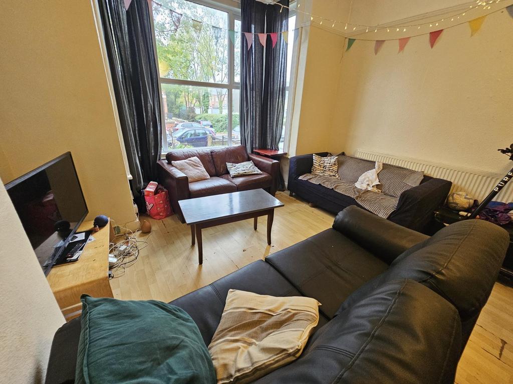 A spacious and well-lit living room featuring a...