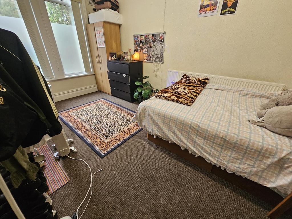 A cozy bedroom featuring a single bed with a pa...