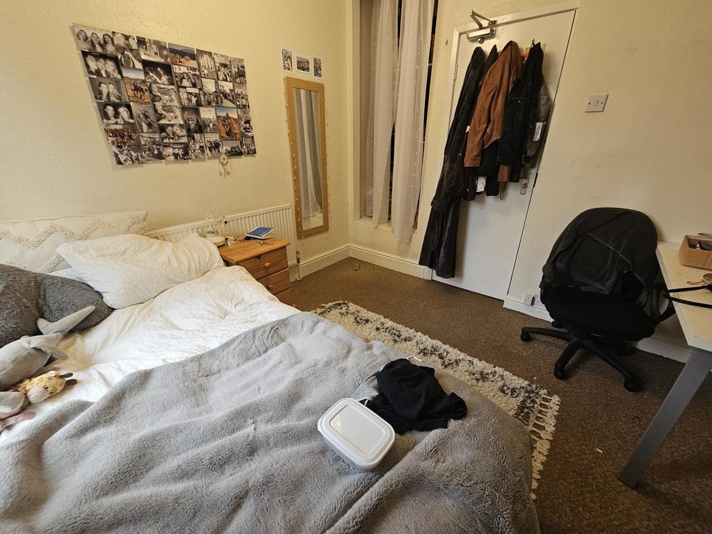 A cozy bedroom featuring a bed, a mirror, and s...
