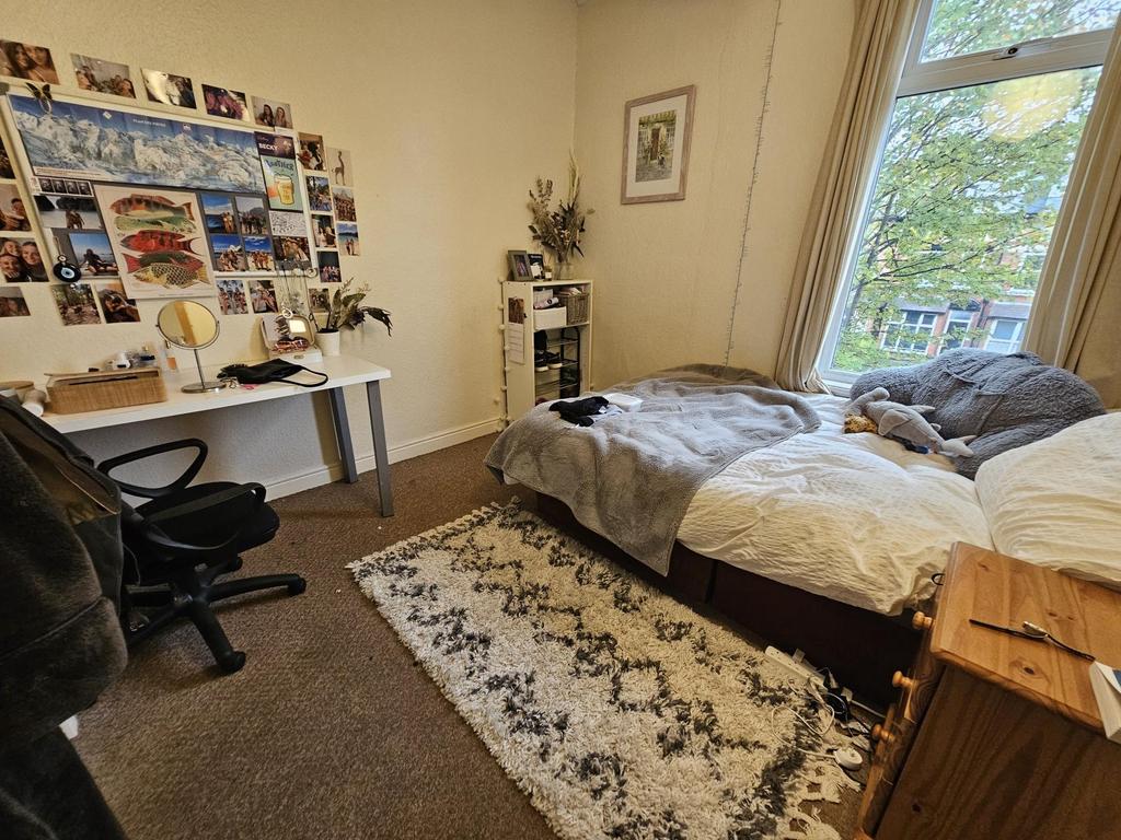 Cozy bedroom featuring a double bed, well-lit w...
