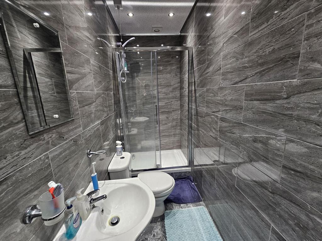 A modern bathroom with sleek, dark wall tiles a...