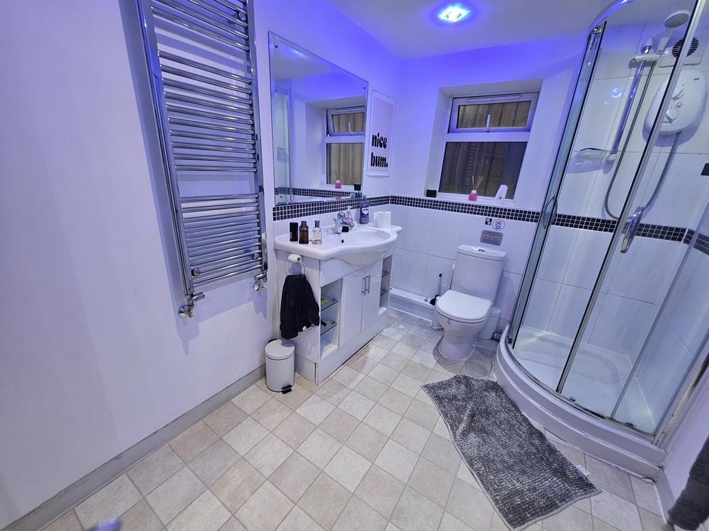 A modern, clean bathroom featuring a shower enc...