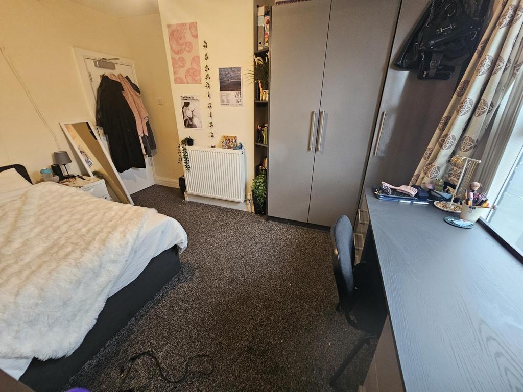 A cozy student bedroom featuring a comfortable ...