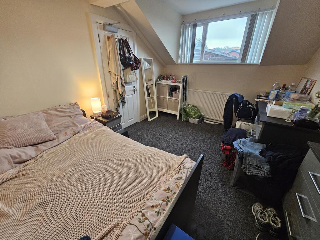 A cozy bedroom featuring a double bed, a study ...
