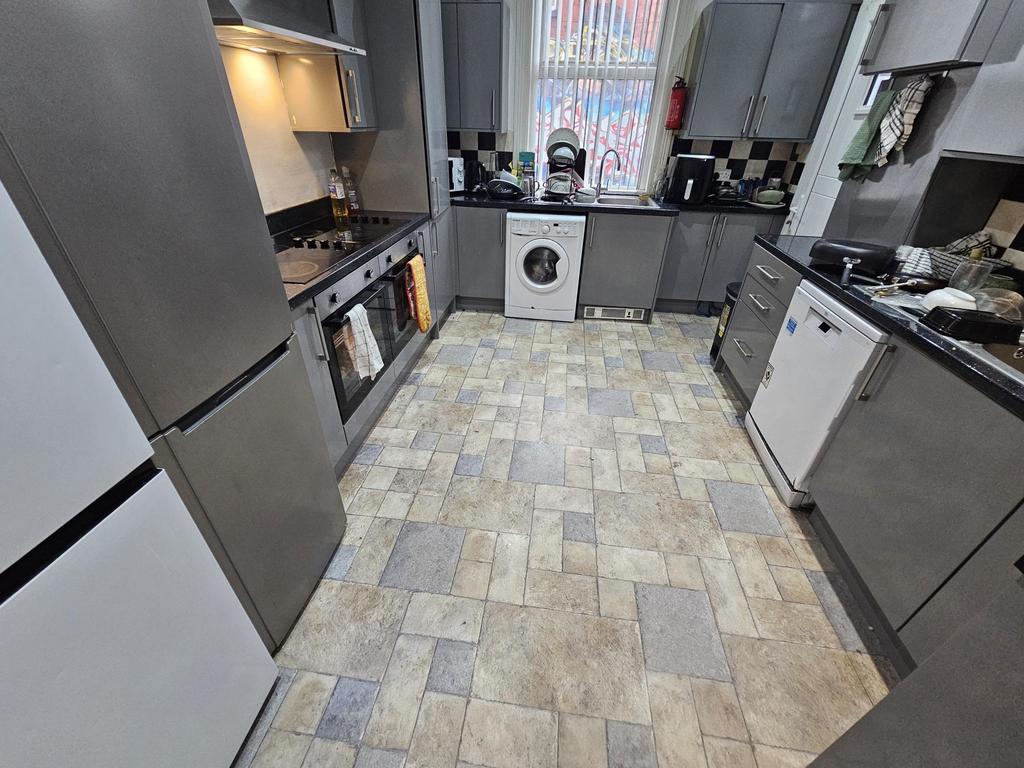 Modern kitchen with sleek grey cabinets, a vari...