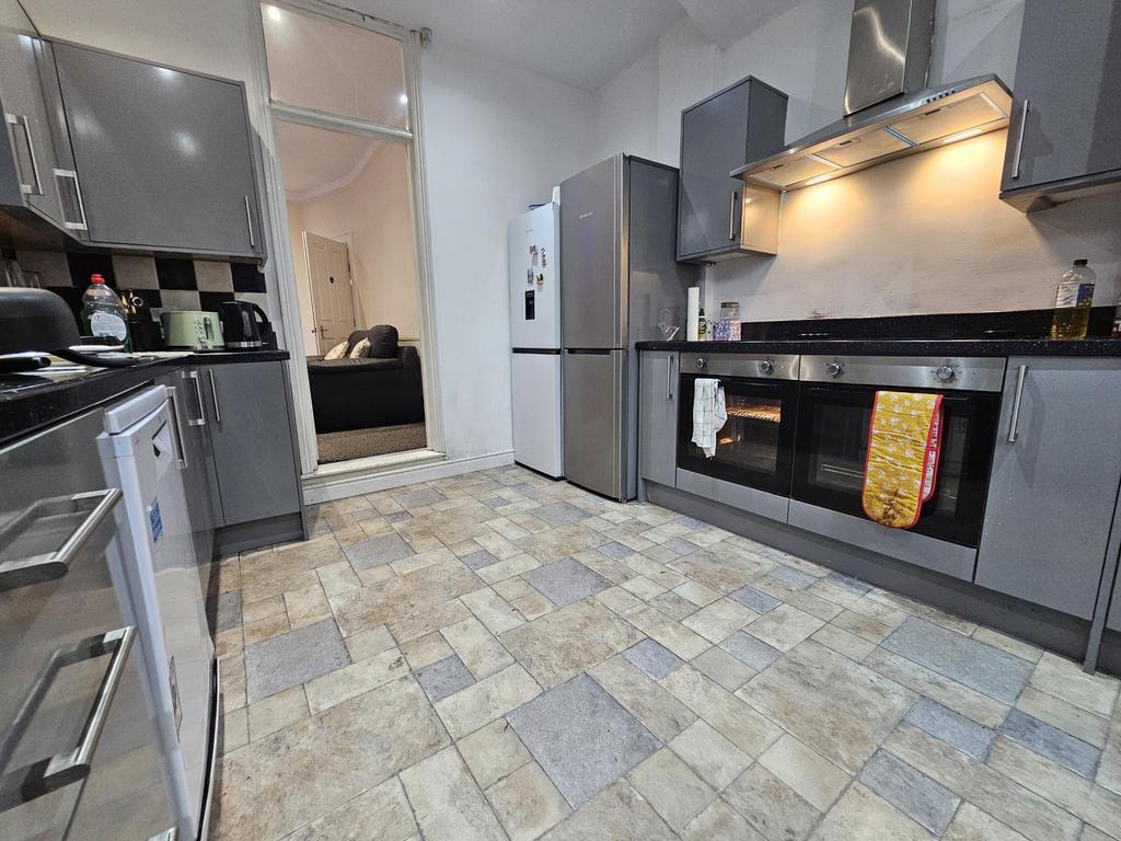 Modern fitted kitchen with grey cabinets, integ...