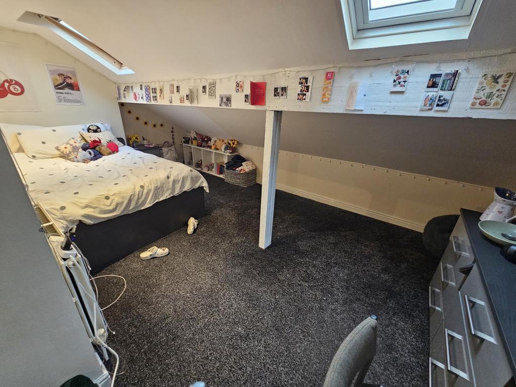 A cozy single bedroom featuring a neatly made b...