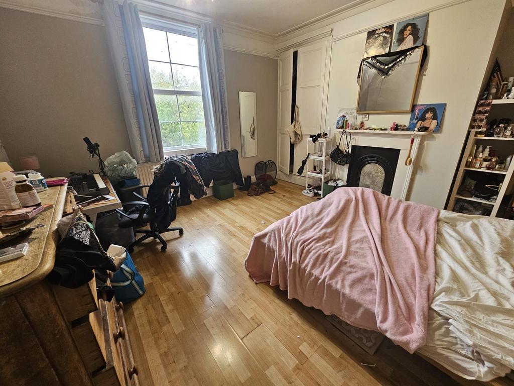 A cozy bedroom with a large window allowing nat...