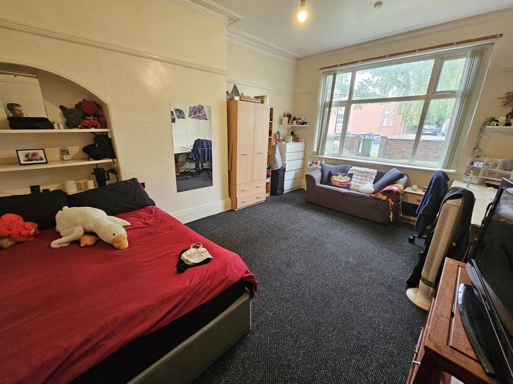 Spacious and well-lit master bedroom with a com...