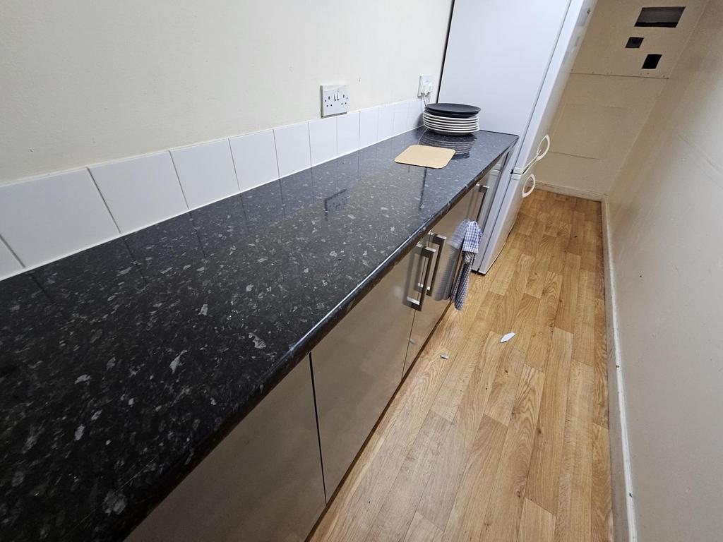 A modern kitchen with a black granite counterto...