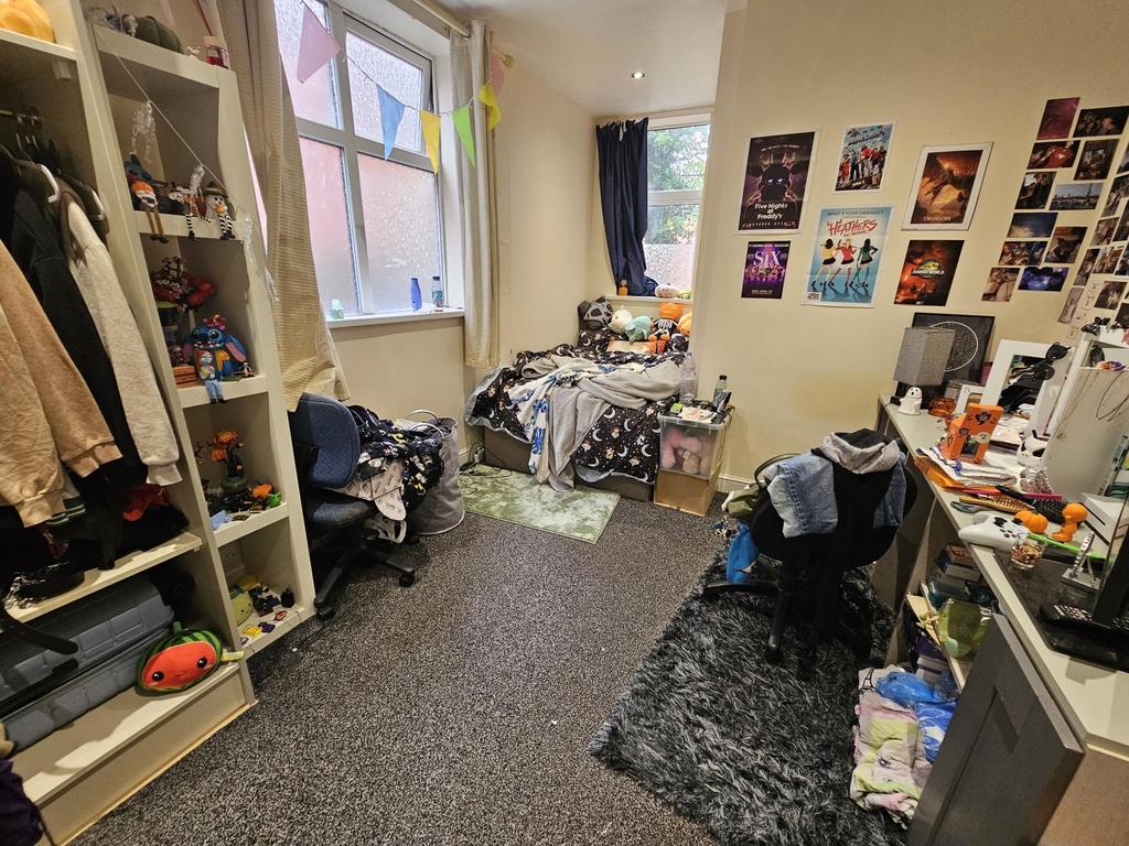 A compact bedroom with personal belongings scat...