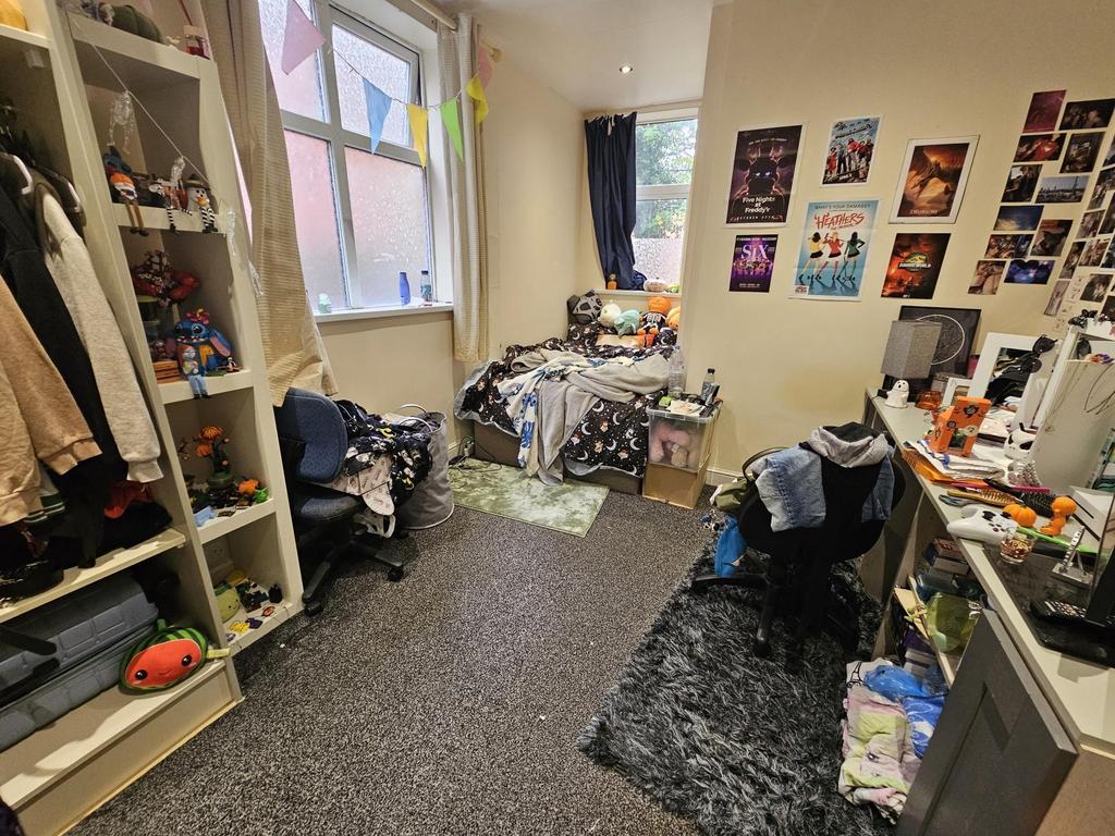 A cozy bedroom filled with personal belongings,...