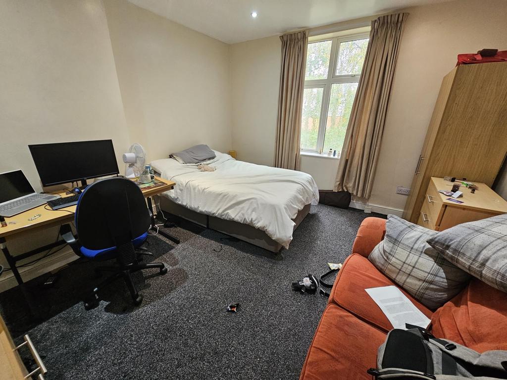 A cozy bedroom featuring a comfortable bed, a d...