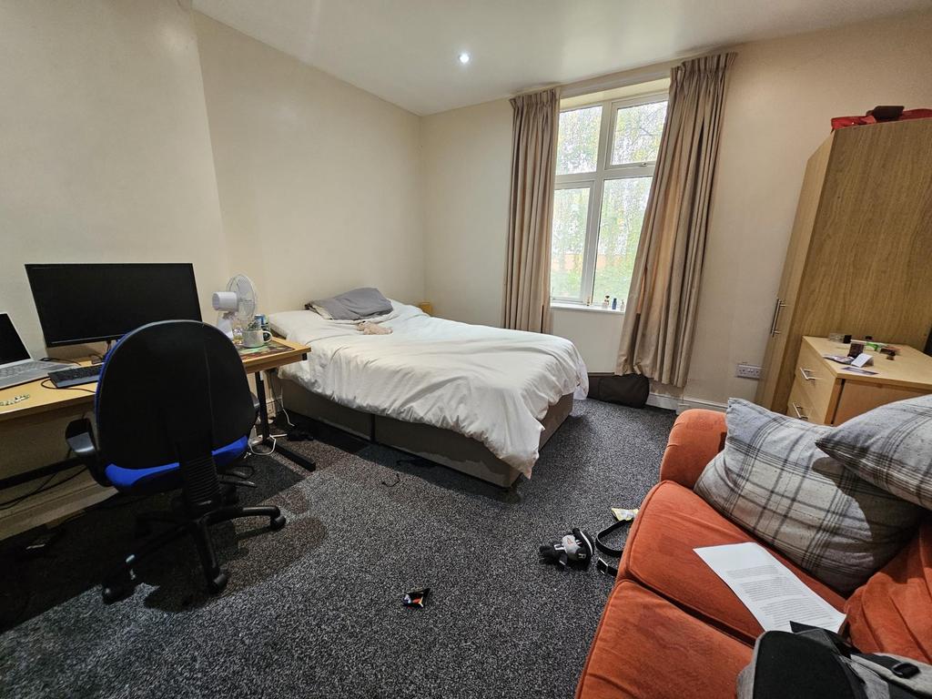 A bright and welcoming bedroom with a comfortab...