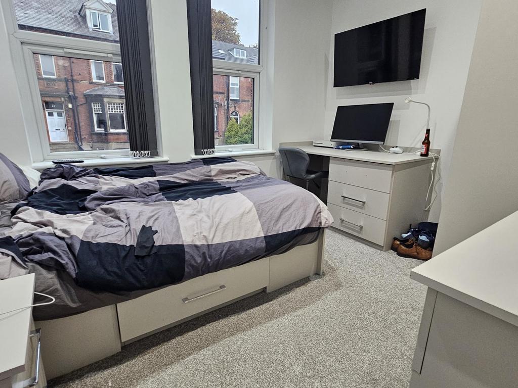 A well-lit, tidy bedroom featuring a double bed...