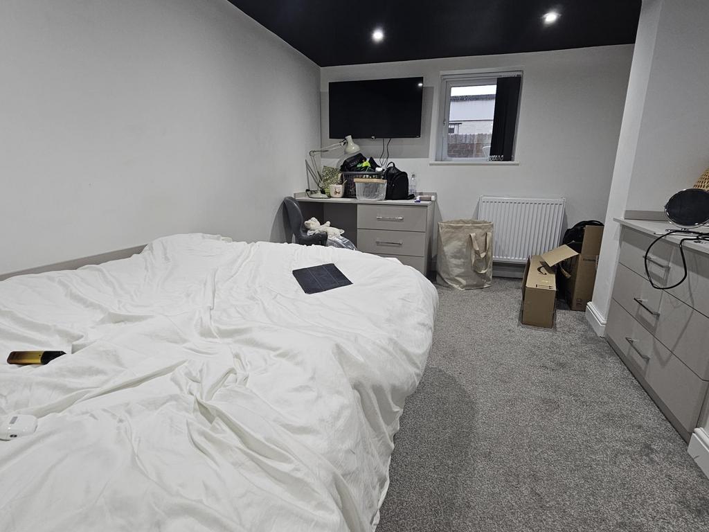 A well-maintained bedroom featuring a large dou...