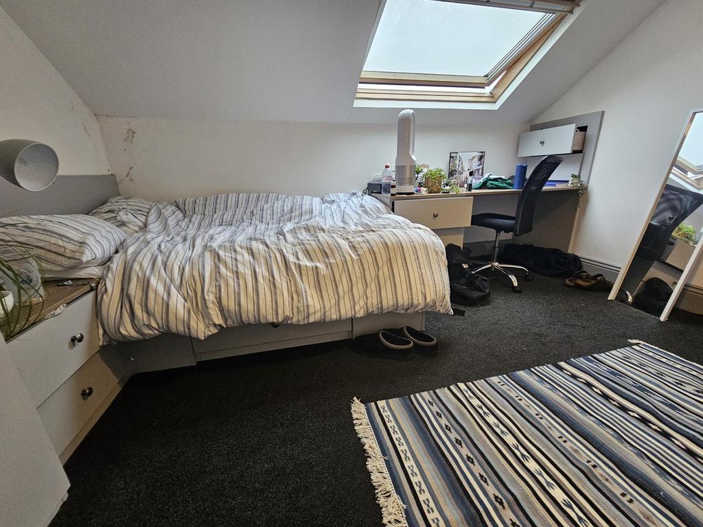 A bright, well-maintained bedroom with a single...