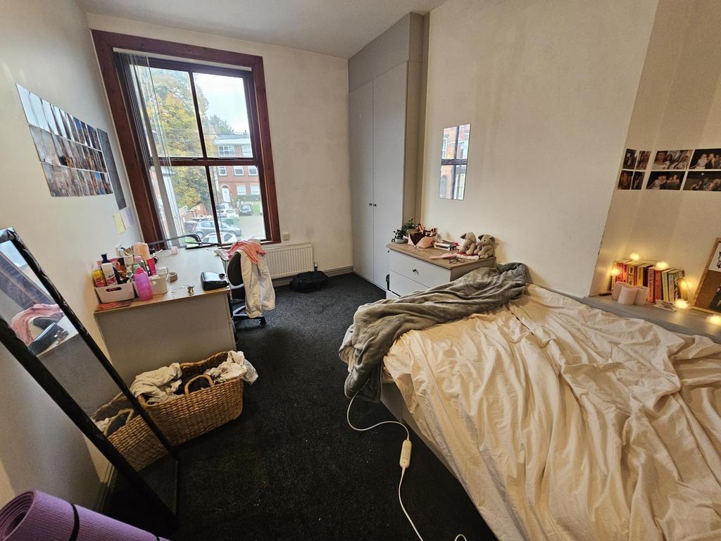 A cozy bedroom featuring a large window that al...