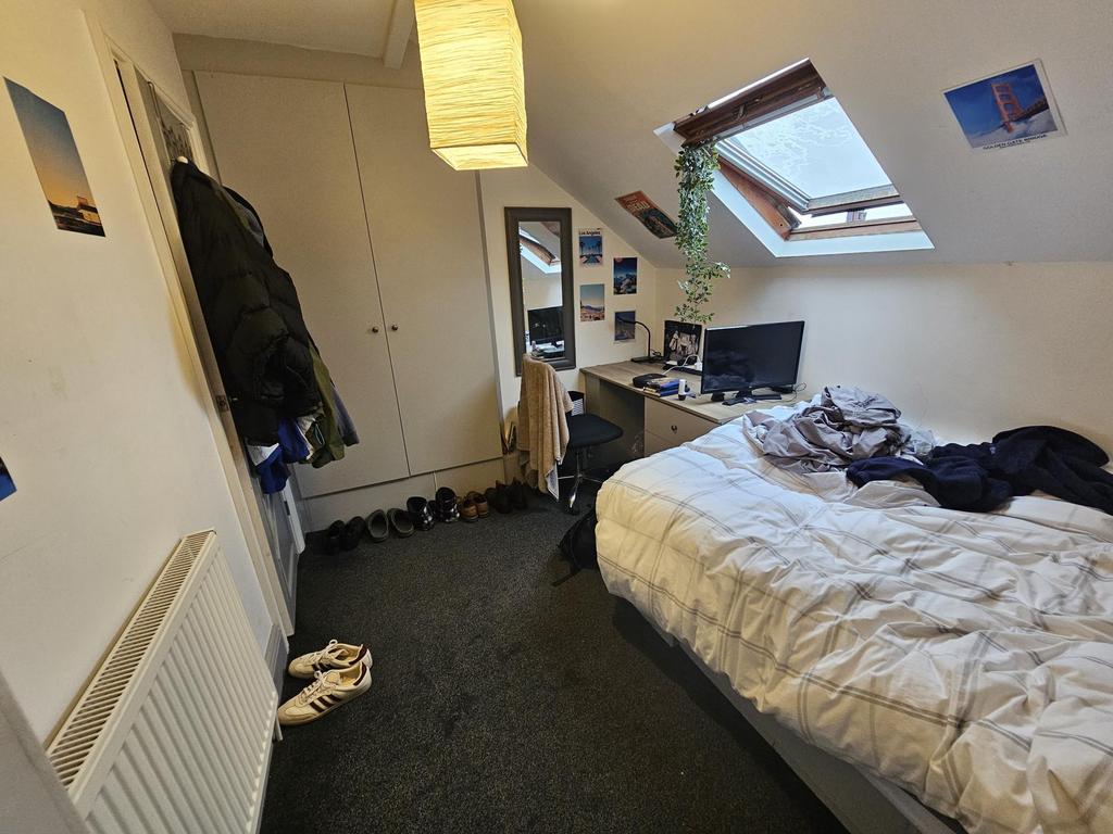 A cozy bedroom featuring a single bed positione...