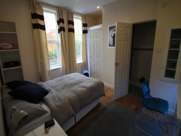 A cozy bedroom featuring a single bed near a wi...