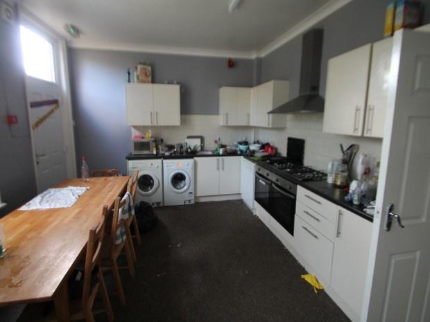 A modern kitchen with white cabinetry and appli...