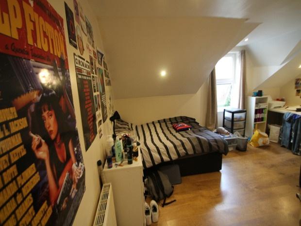 A cozy bedroom with a bed, some posters on the ...