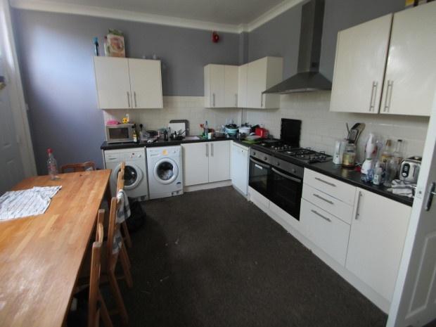 A functional kitchen with white cabinetry and a...